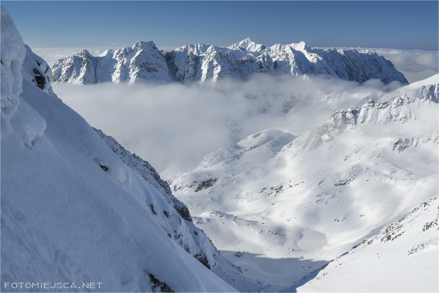 Grań Baszt ponad chmurami trawers Ciężkiego Szczytu Tatry Wysokie zimą widok z Przełęczy Waga